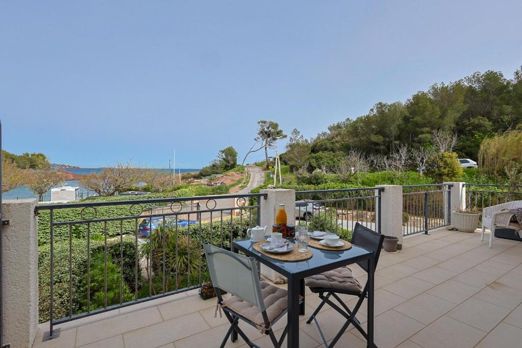 une table et des chaises sur le balcon d'une maison dans l'établissement Apartment Tiki Plage mit Meerblick und direkt am Strand, à Saint-Raphaël