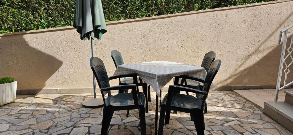 uma mesa com cadeiras e um guarda-sol num pátio em Apartment LAGUNA 22 em Izola