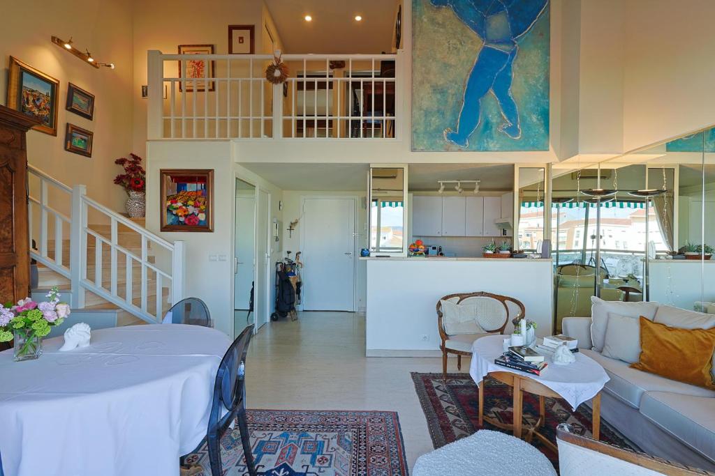 ein Wohnzimmer mit einem Tisch und einer Küche in der Unterkunft Appartement Globetrotter in Saint-Raphaël