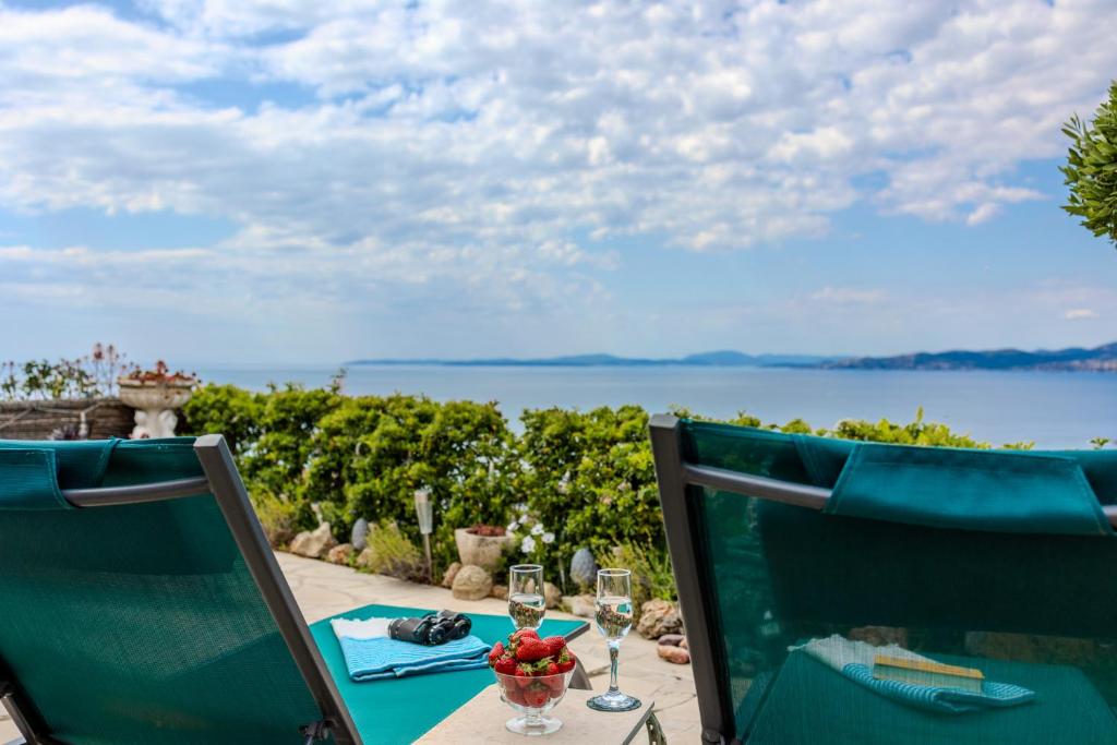 - une table avec deux chaises et une vue sur l'eau dans l'établissement Provenzalische Villa Citronniers - Garten mit Meerblick und Pool by Riviera HomeLife, à Saint-Raphaël
