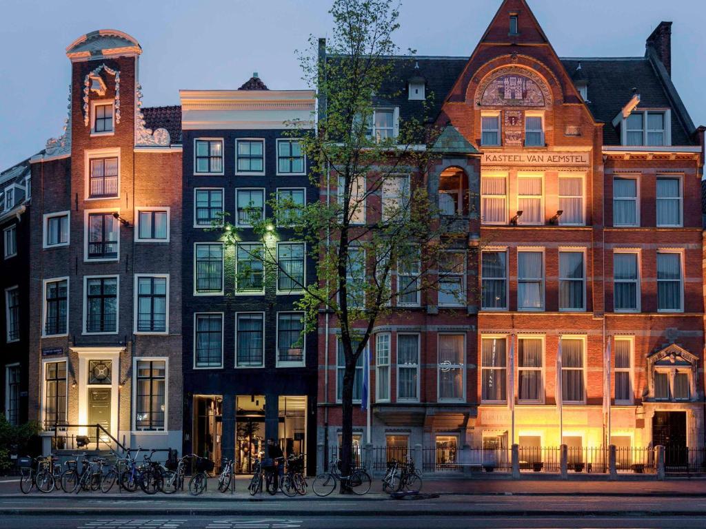 un groupe de bâtiments avec des vélos garés devant eux dans l'établissement INK Hotel Amsterdam - MGallery Collection, à Amsterdam