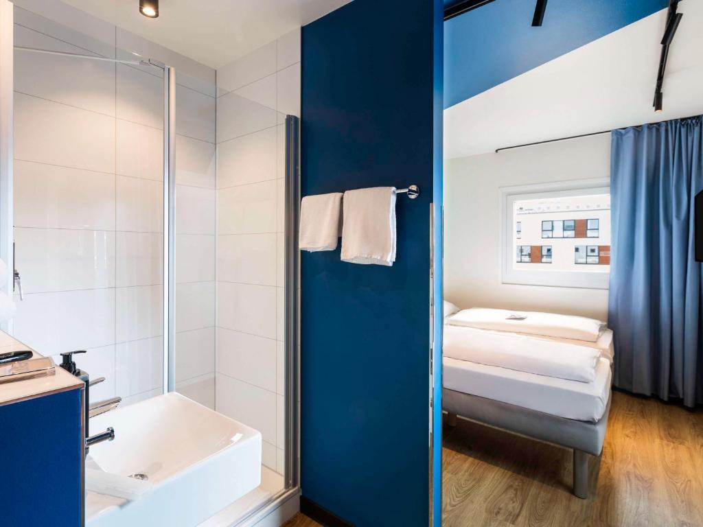 La salle de bains est pourvue d'une douche, d'un lavabo et d'une baignoire. dans l'établissement ibis budget Ludwigsburg -RENOVIERT IN 2024!-, à Ludwigsbourg