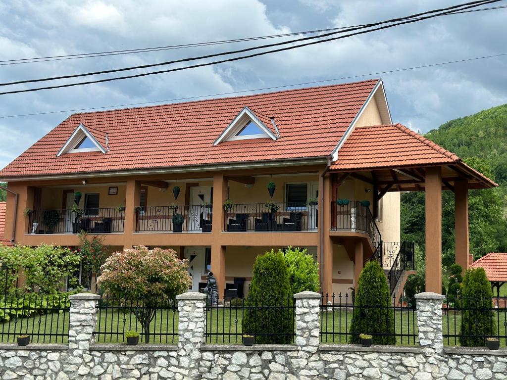a house with a red roof and a fence at Casa Antonia in Chişcău