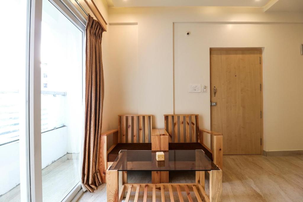 um quarto com uma mesa e duas cadeiras e uma porta em Collection O Prime Residency em Bangalore