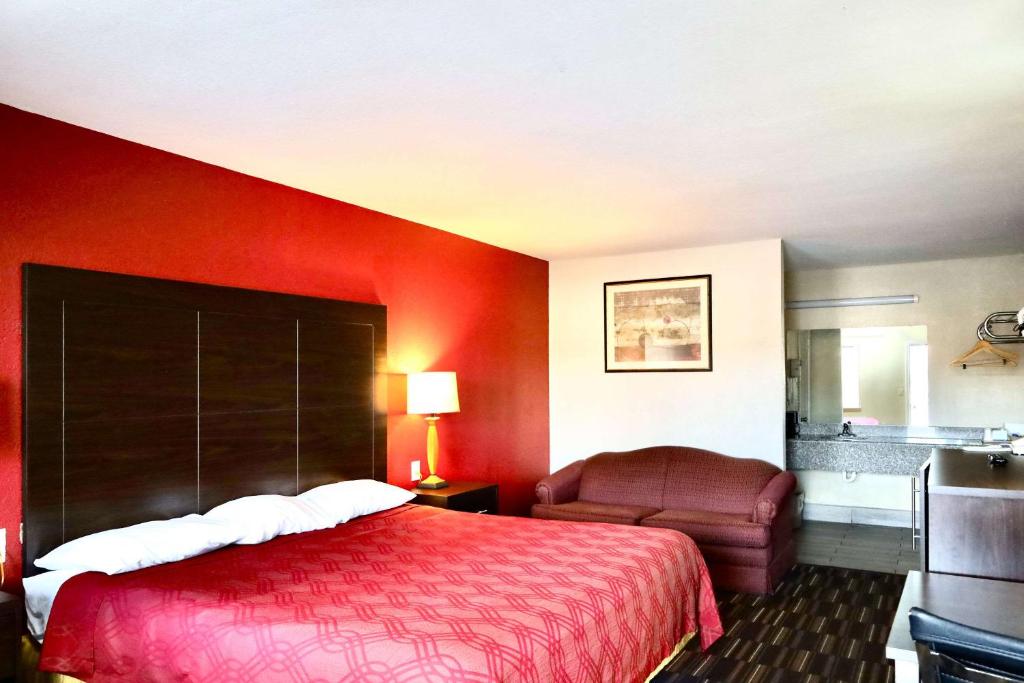 a hotel room with a bed and a chair at Rodeway Inn in Pauls Valley