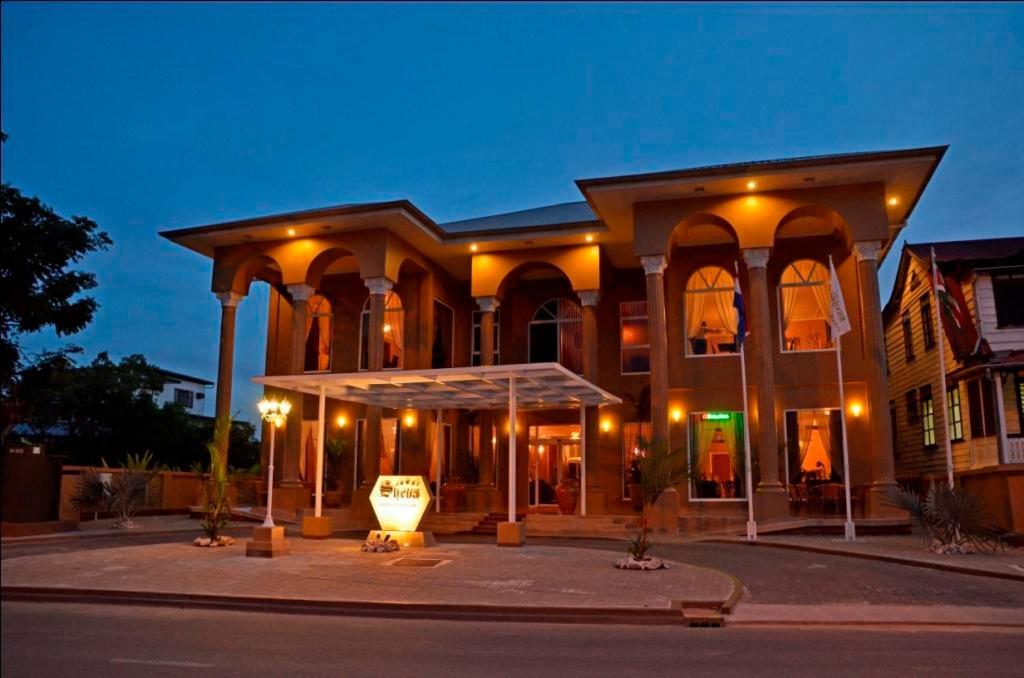 a large building with lights on a street at Sheva Hotel in Paramaribo