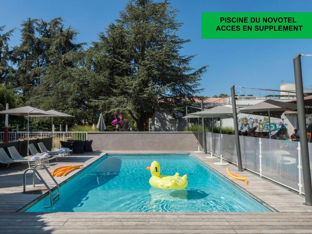 una piscina con un pato de goma en el agua en ibis Styles Lyon Bron Eurexpo en Bron
