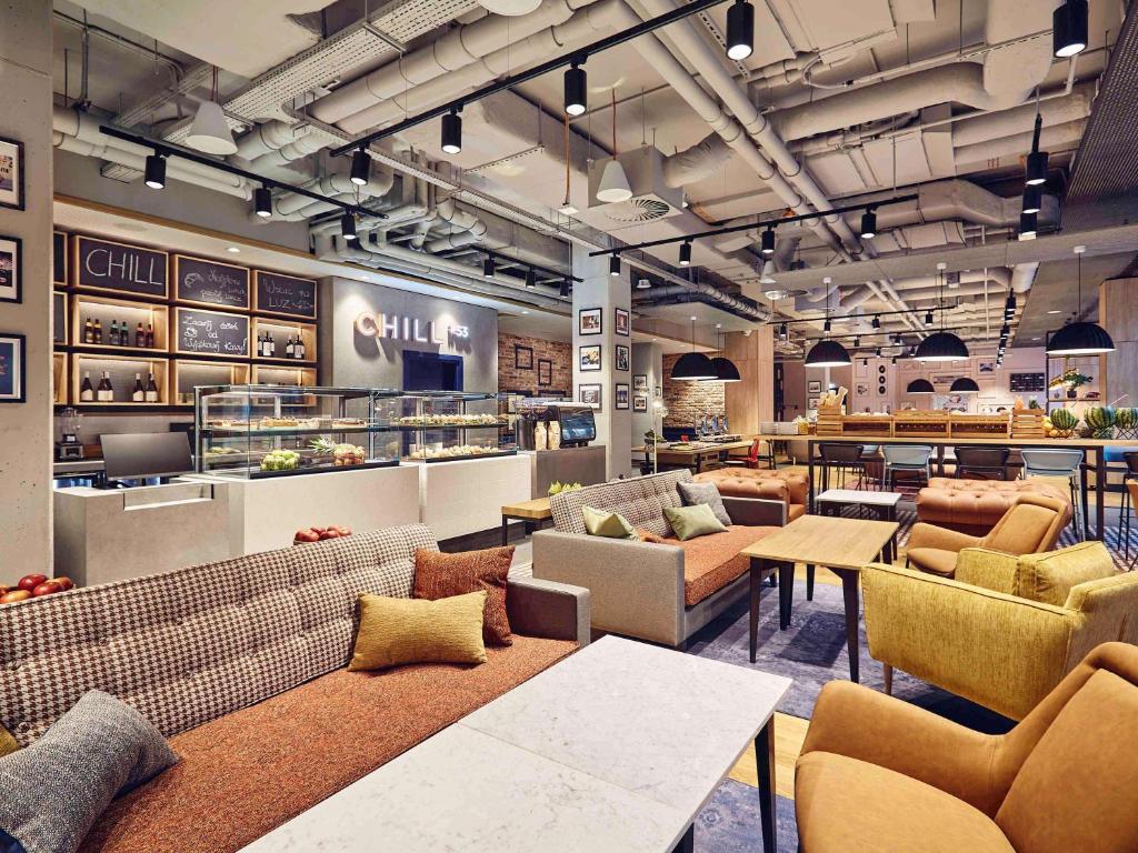 a restaurant with couches and tables in a room at ibis Styles Kraków Centrum in Krakow