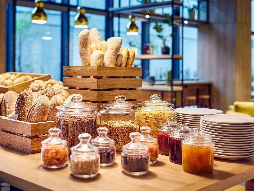 a table with jars of food and plates and bread at ibis Styles Kraków Centrum in Krakow