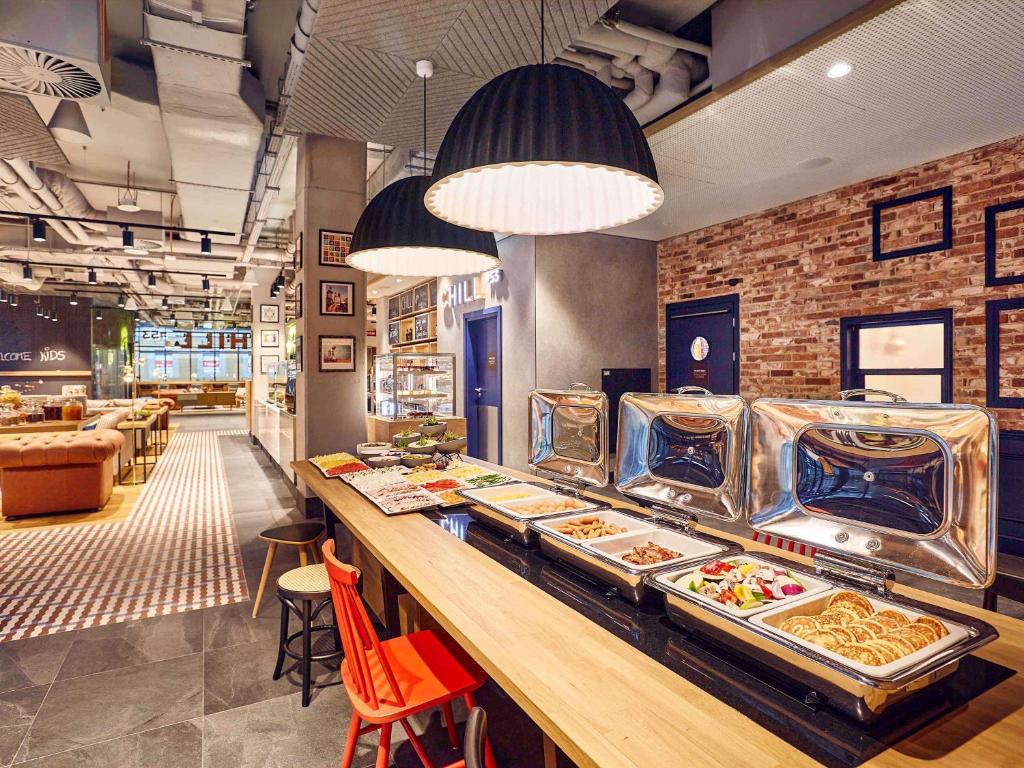 a restaurant with a buffet line with food at ibis Styles Kraków Centrum in Krakow