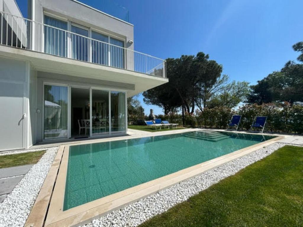 een zwembad voor een huis bij Stunning villa with pool and lagoon view in Palazzo Vianello