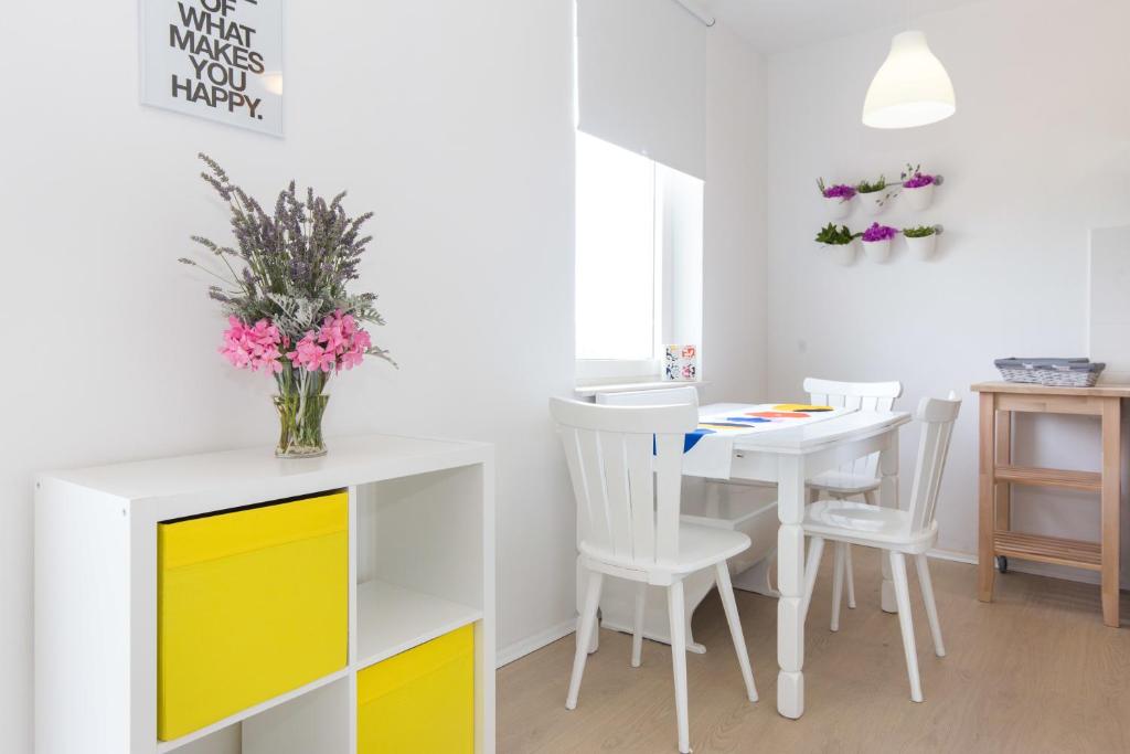 a dining room with a white table and yellow cabinets at Apartment Jakov in Matulji