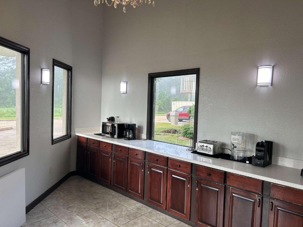 a kitchen with wooden cabinets and a large window at Motel 6 Hammond, LA – I 12 – I 55 in Hammond