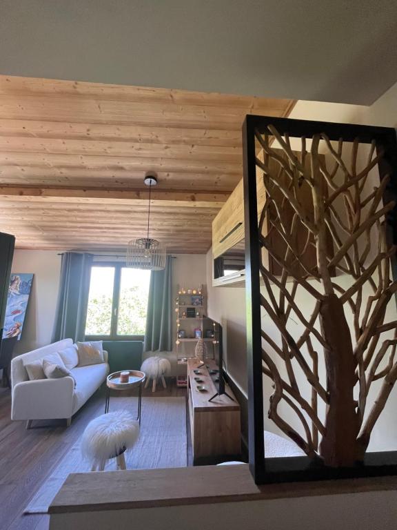 un salon avec le reflet d'un arbre dans un miroir dans l'établissement Appartement cosy pieds des pistes, aux Houches