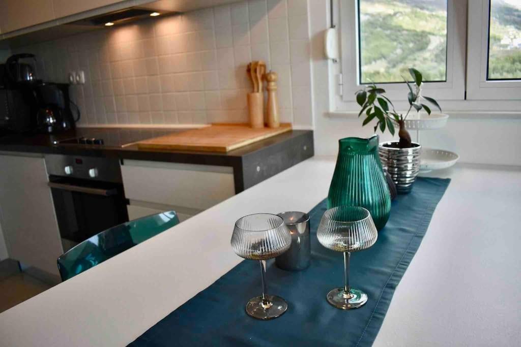 a kitchen with two wine glasses on a counter at Bubbles Penthouse with Jacuzzi in Podstrana