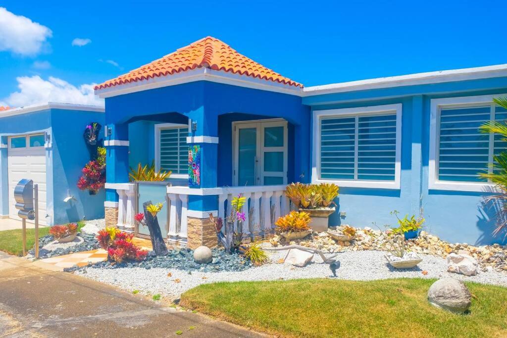 una casa azul con un jardín frente a ella en Blue Paradise - - Fajardo, PR, en Fajardo