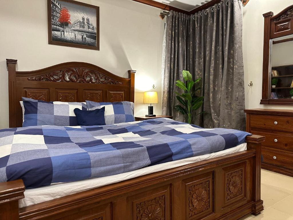um quarto com uma cama de xadrez azul e branco em Shaiz Apartments Bhurban, Murree em Murree