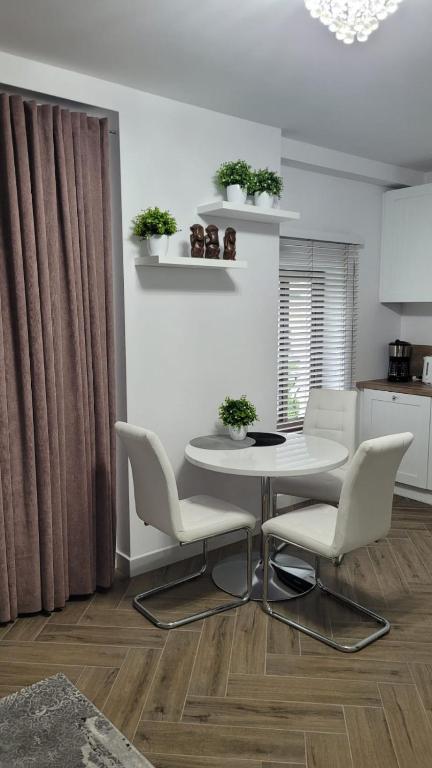 a white dining room with a table and chairs at APARTAMENT JARACZA 28/14 in Słupsk