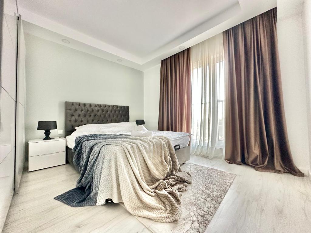 a white bedroom with a bed and a window at Double Studio A305 StayInn by Cosmopolis in Ştefăneştii de Jos