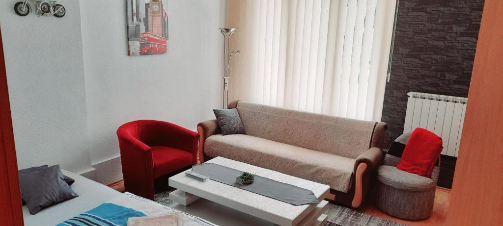 ein Wohnzimmer mit einem Sofa und einem roten Stuhl in der Unterkunft Irma in Tuzla