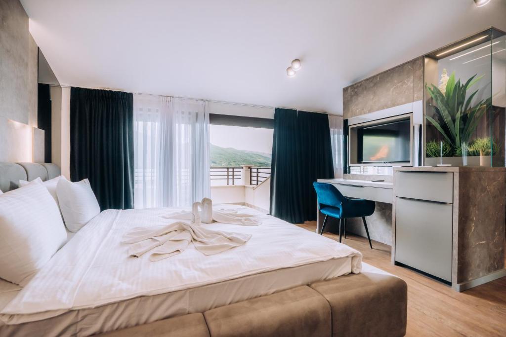 Schlafzimmer mit einem großen Bett, einem Schreibtisch und einem Schreibtisch in der Unterkunft Hotel Aleksandrija in Ohrid
