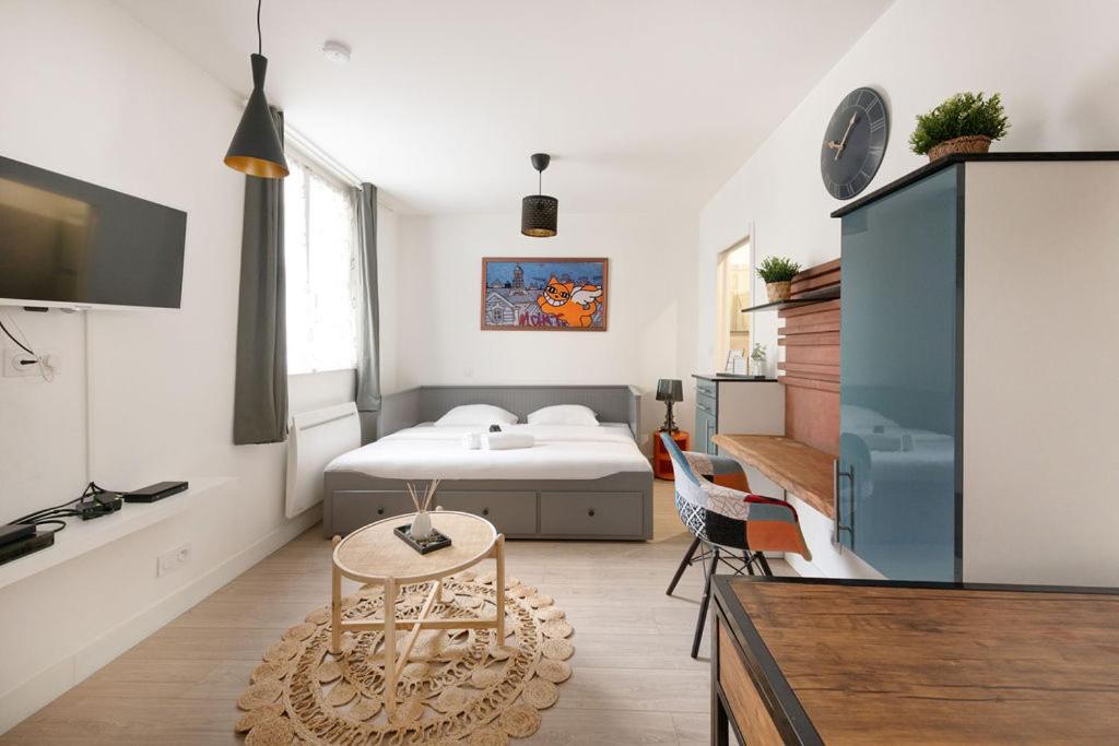 een slaapkamer met een bed en een tafel in een kamer bij Chaleureux Studio 2 pers in Lyon