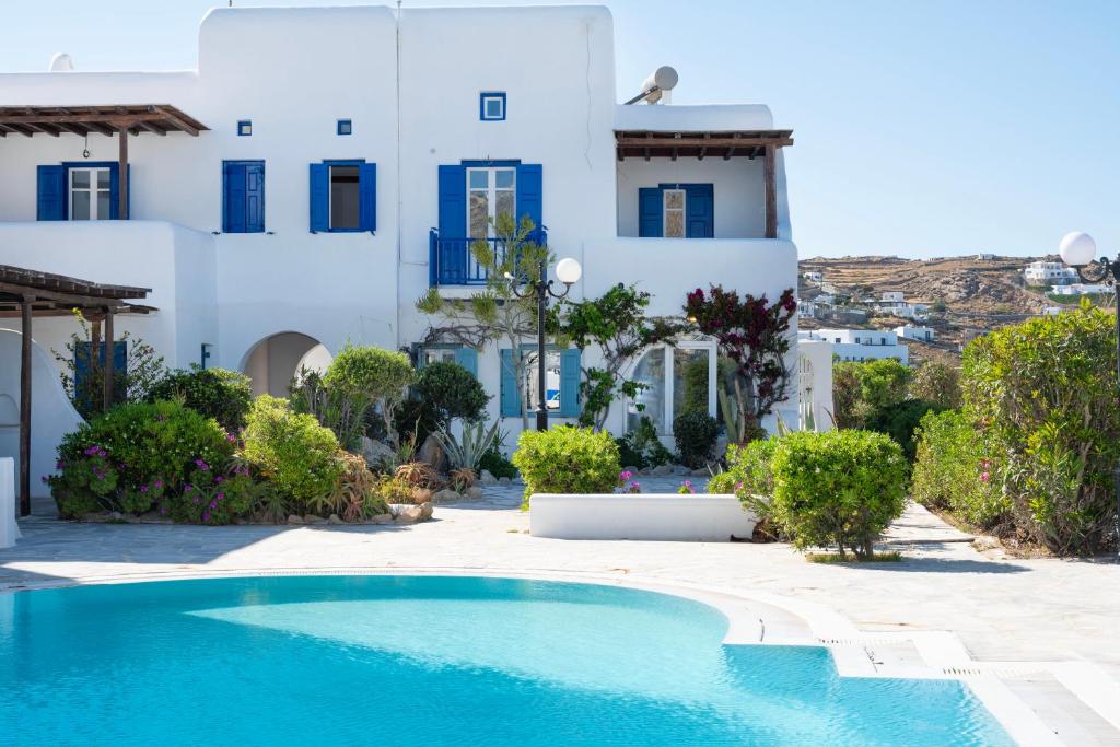 a swimming pool in front of a white building at Charisma House Ornos Beach Mykonos in Mýkonos City