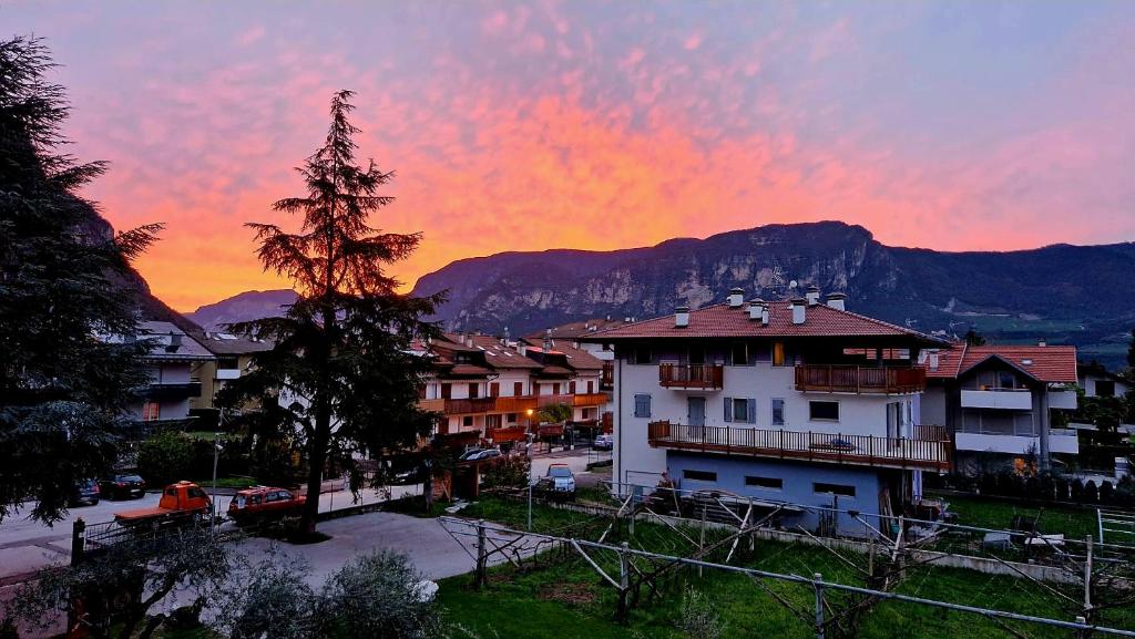 a sunset over a town with buildings and mountains at Antico Fienile Agritur in Mezzocorona