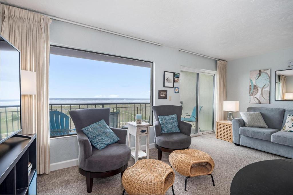 a living room with a couch and chairs and a large window at Seaside Beach Club 203 in Seaside