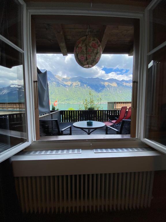 uma janela com vista para um pátio com uma mesa e cadeiras em Boutique Hotel Bellevue B&B am Brienzersee Iseltwald Interlaken em Iseltwald