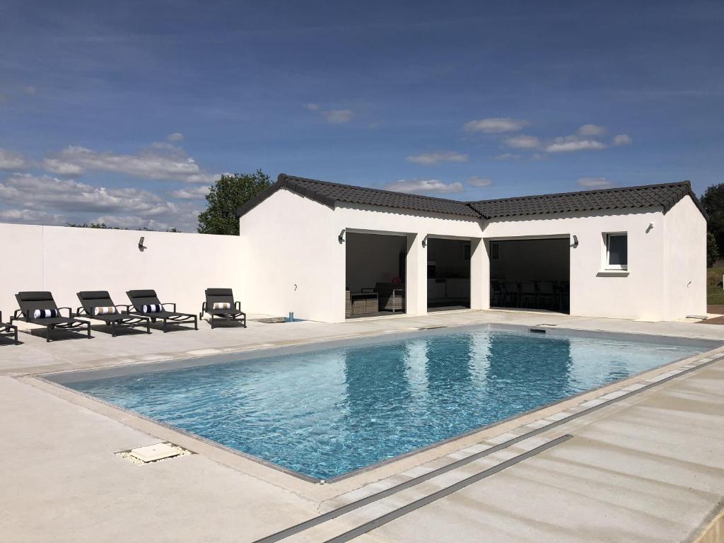 a swimming pool in front of a white house at Villa Alice 8 pers avec piscine in La Garnache
