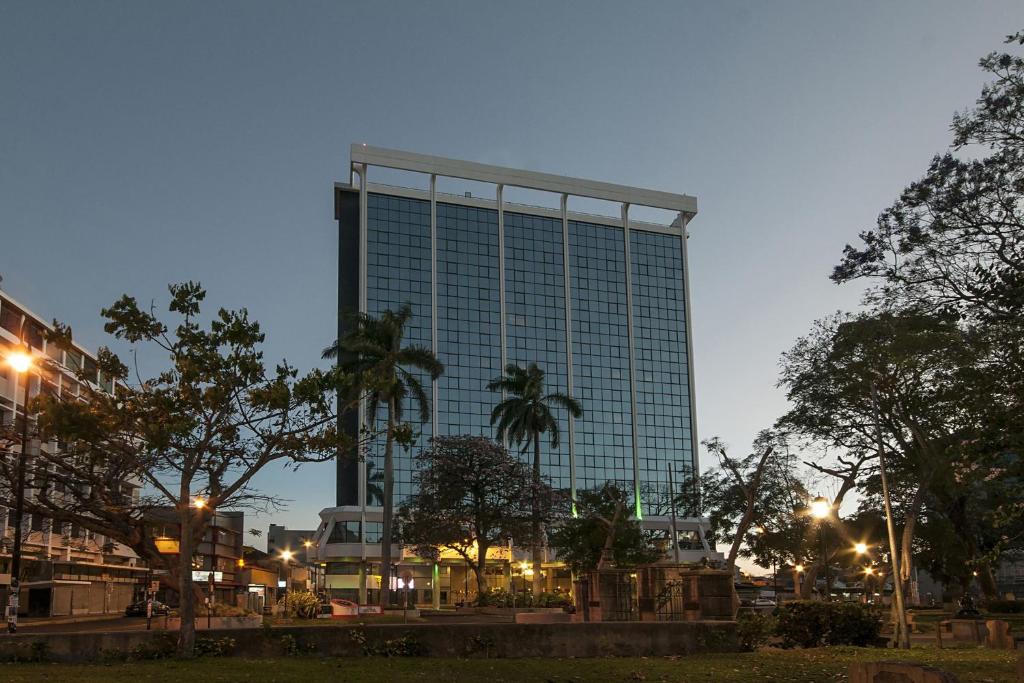 un edificio de cristal alto con árboles delante de él en Delta Hotels by Marriott San Jose Aurola en San José