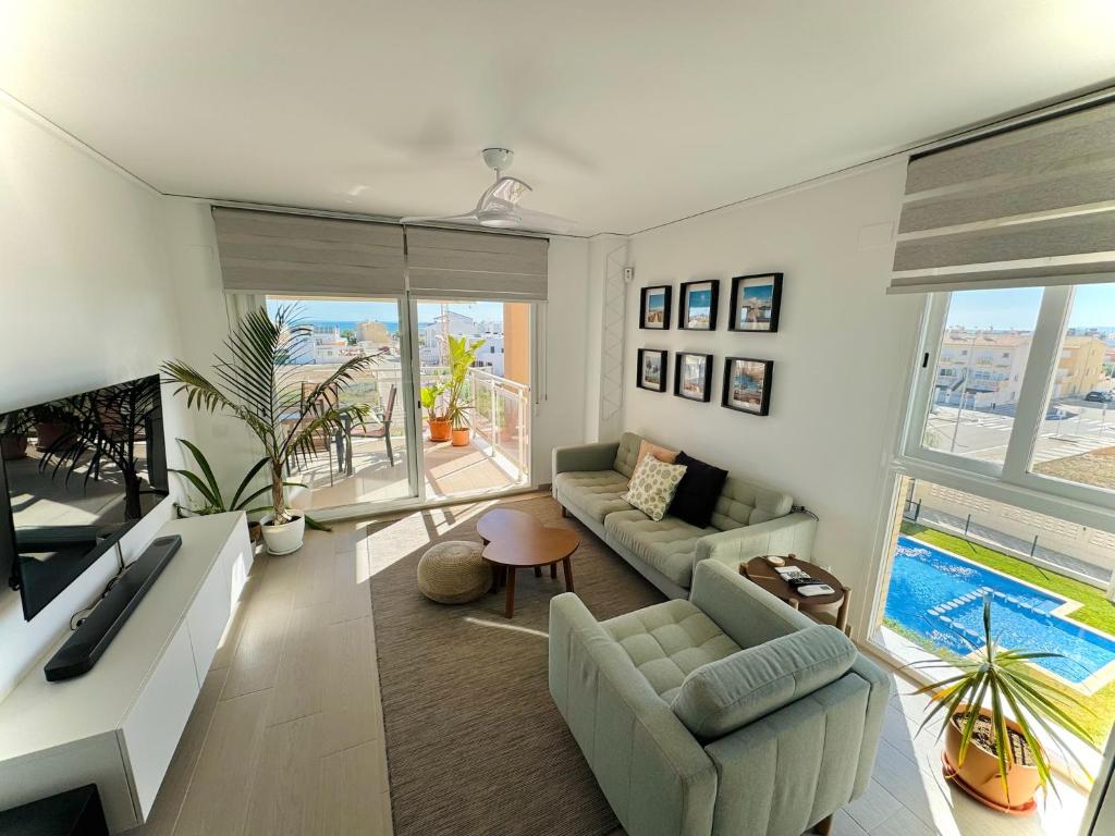 a living room with a couch and a tv at Apartamento Playa Oliva in Oliva