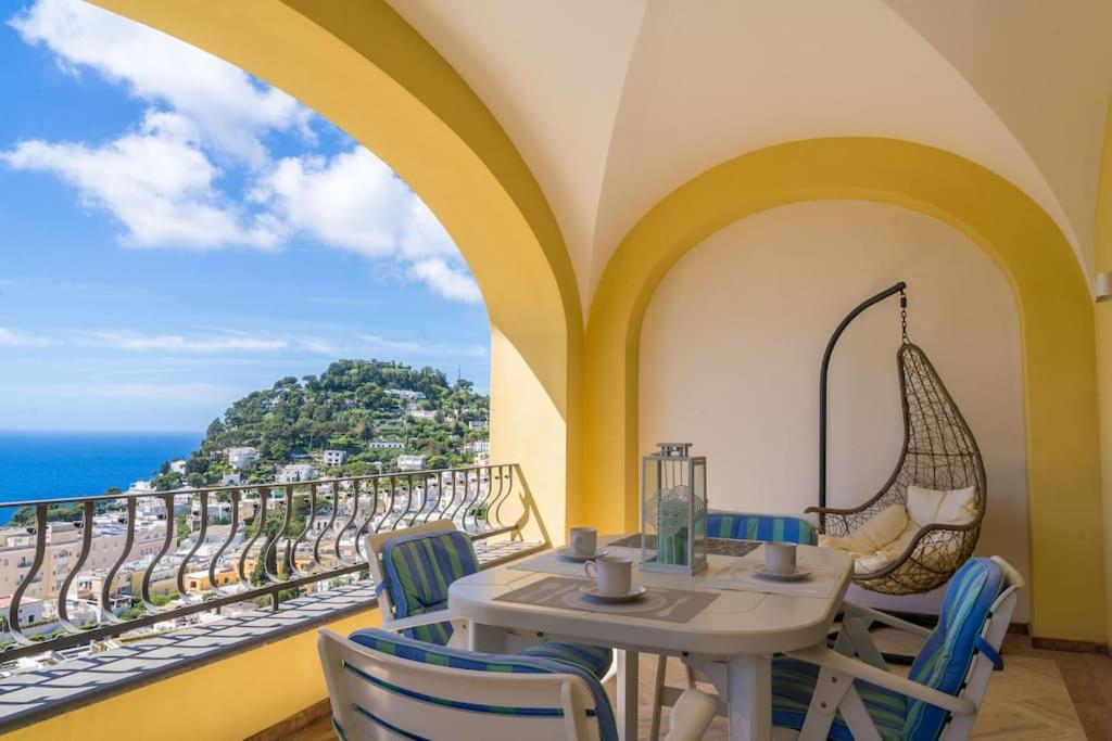 ein Esszimmer mit einem Tisch, Stühlen und Meerblick in der Unterkunft Residenza "il sogno di Geppino" al centro di Capri in Capri