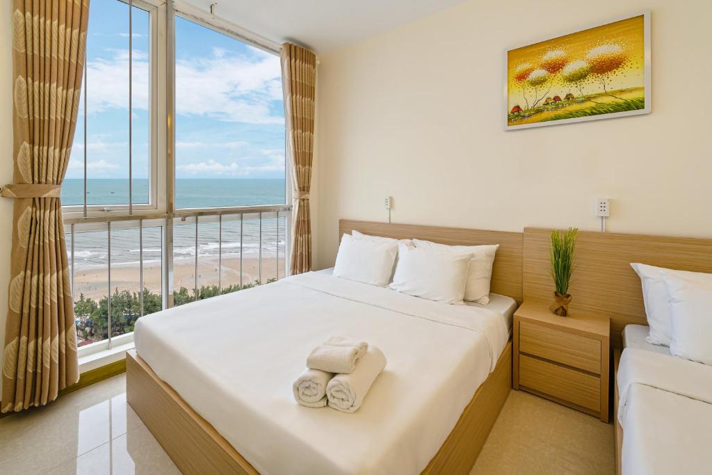 Un dormitorio con una cama con vista al mar. en Căn hộ Oasky 2-3-4 phòng ngủ, en Vung Tau