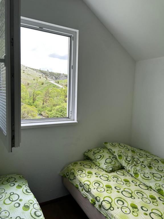 um quarto com uma cama e uma janela em Odmorište Vrelo Vape em Sjenica