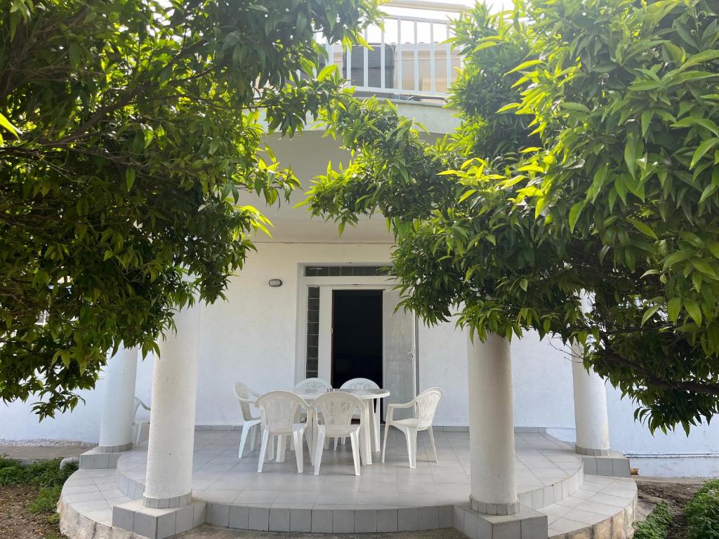 a table and chairs in front of a white house at Pegasus House in Kórinthos