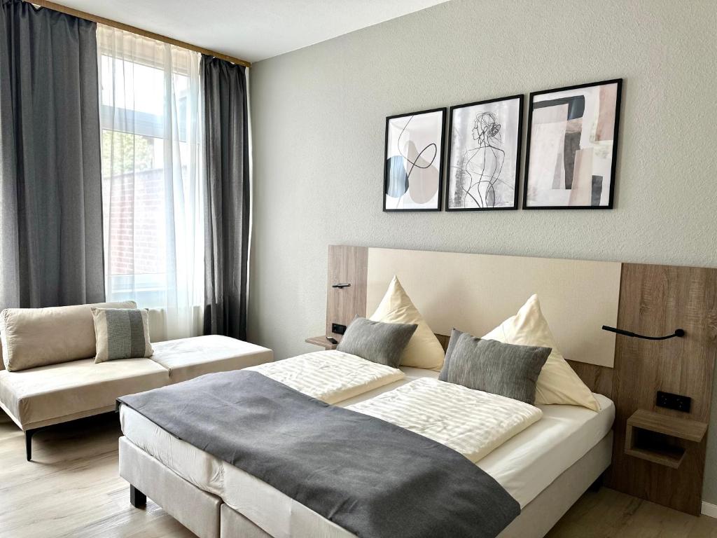 een hotelkamer met een bed en een bank bij City Hotel Hameln in Hameln