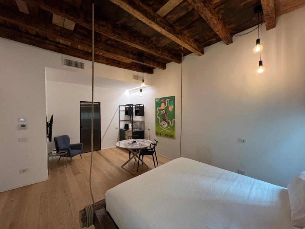 um quarto com uma cama, uma mesa e cadeiras em Dream Suite Lago D’iseo em Lovere