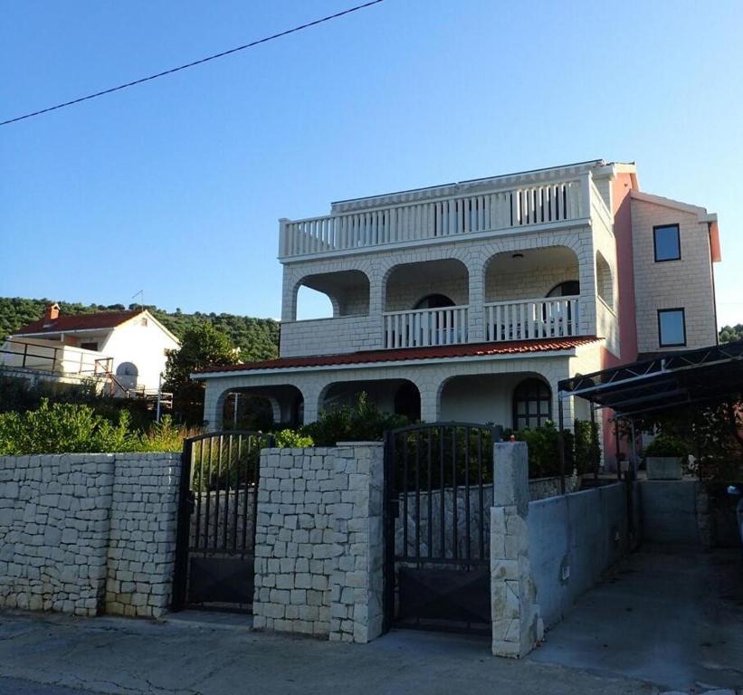 a large house with a fence in front of it at Apartman Daisy in Slatine