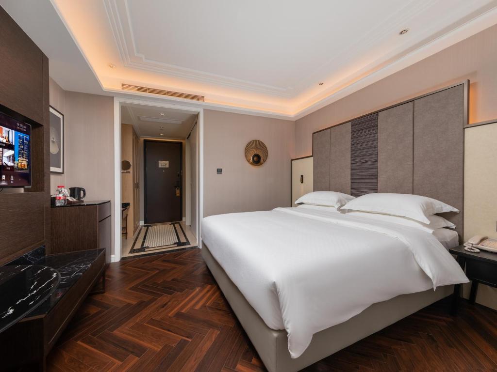 Postel nebo postele na pokoji v ubytování Shenzhen Longgang Central City Jinjiang Metropolo Hotel