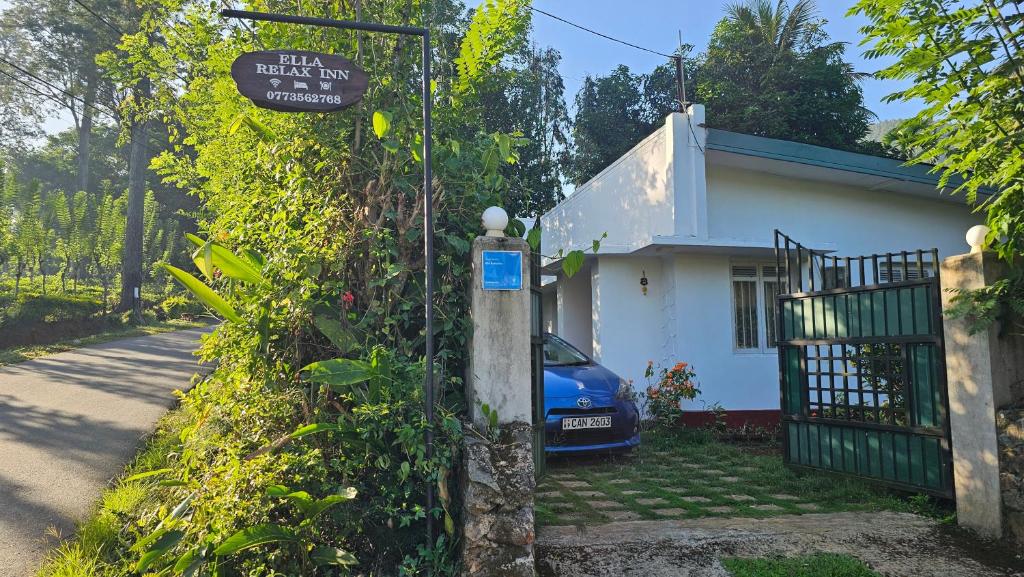 uma casa com um carro azul estacionado em frente em Ella Relax Inn em Ella