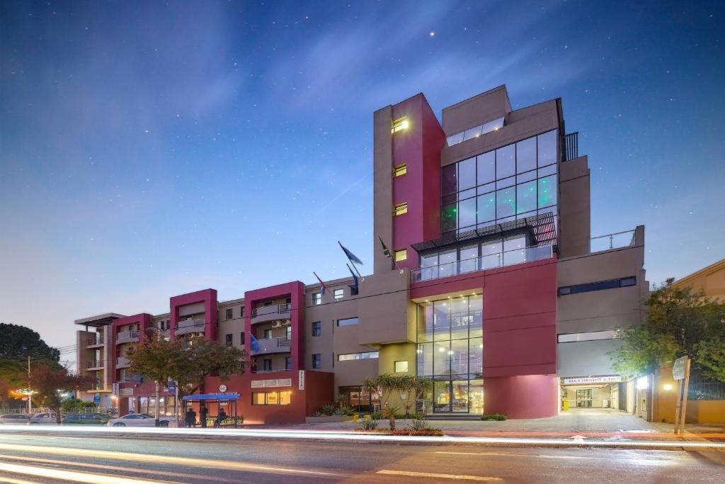 a tall red building with a street in front of it at Protea Hotel by Marriott Pretoria Hatfield in Pretoria