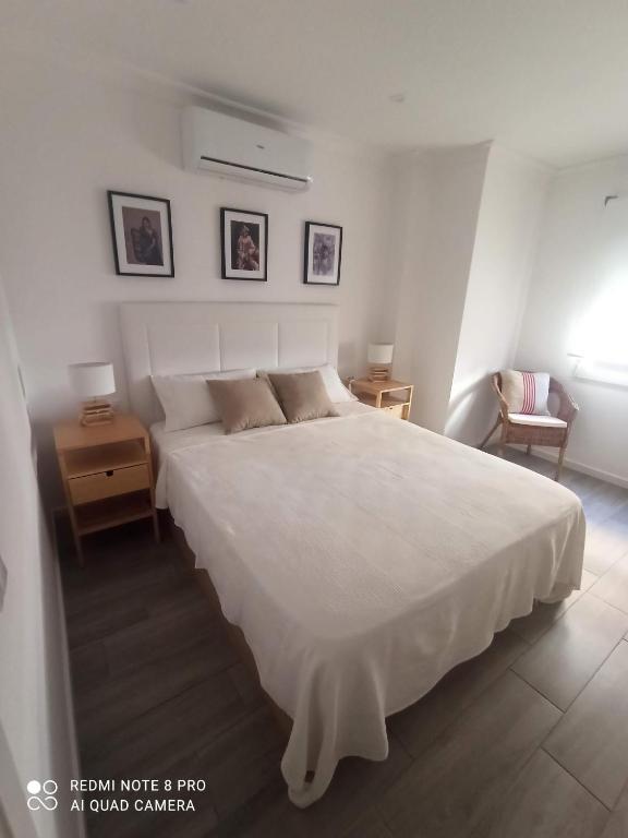 a bedroom with a large white bed and two tables at SUNSHINE GROUP in Málaga