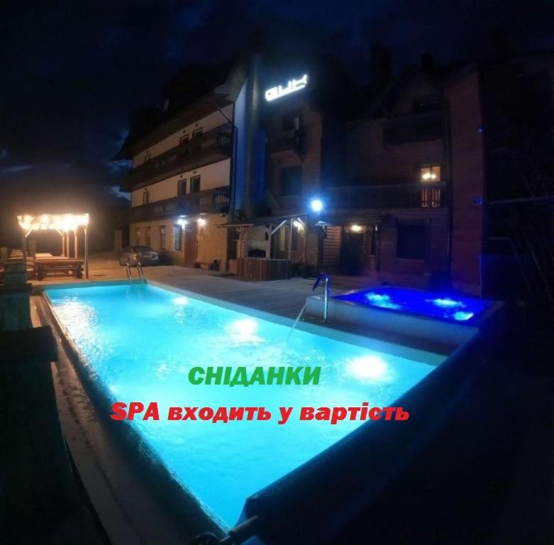 a swimming pool at night with lights in a building at Гук ресторанно-готельний комплекс in Bukovel