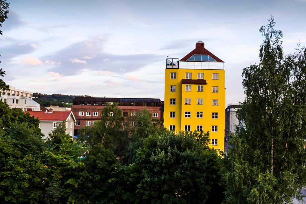 a yellow building in the middle of a city at Aksjemøllen - by Classic Norway Hotels in Lillehammer