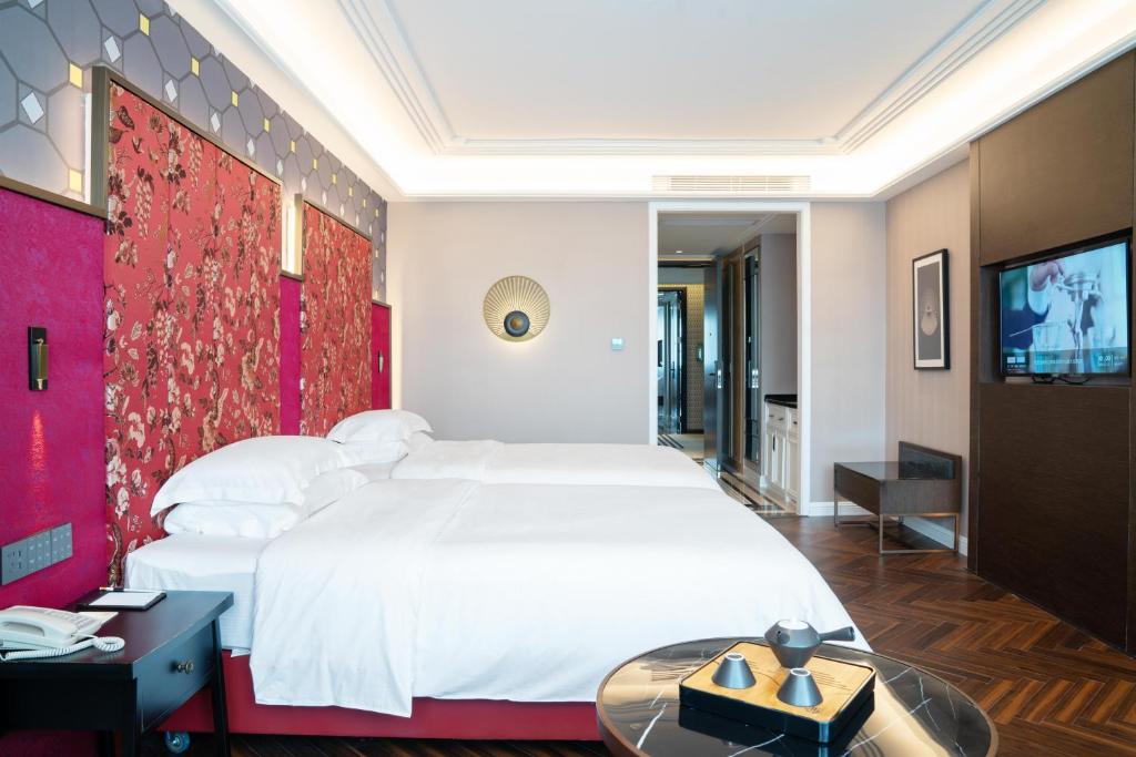 Postel nebo postele na pokoji v ubytování Shenzhen Longgang Central City Jinjiang Metropolo Hotel