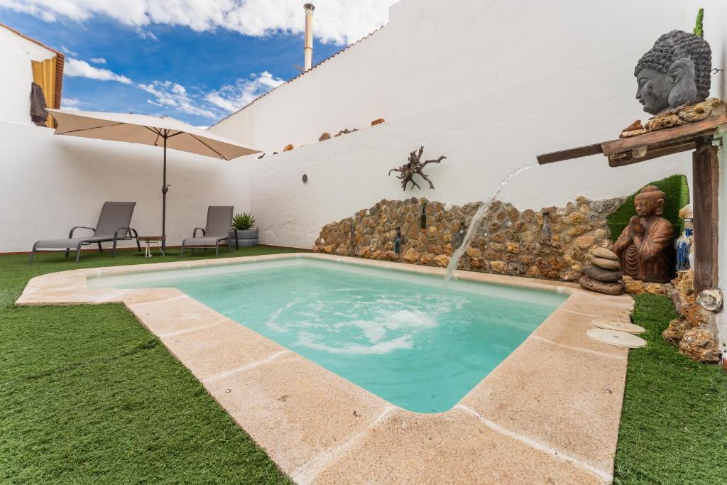 una piscina en un patio con una fuente de agua en Casa Rural con piscina, Hogar de Zoe, en Trujillanos