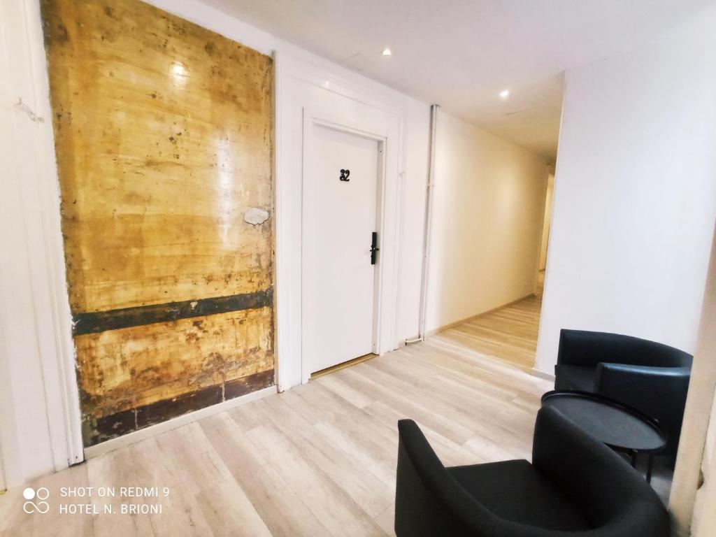 Cette chambre est dotée d'un mur en bois et d'une chaise noire. dans l'établissement Hotel Brioni, à Trieste