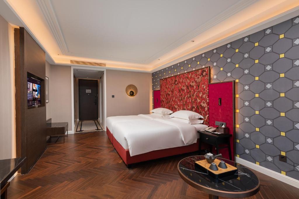 Postel nebo postele na pokoji v ubytování Shenzhen Longgang Central City Jinjiang Metropolo Hotel